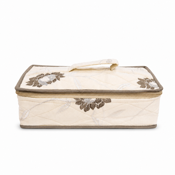 A quilted rectangular fabric storage bag with a zippered lid, featuring a cream-colored body, brown floral embroidery, and a matching top handle, shown against a plain white background.